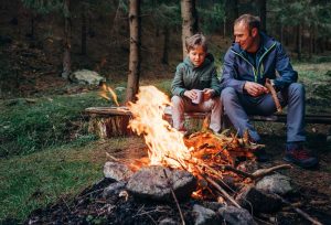 A father and son by a campfire