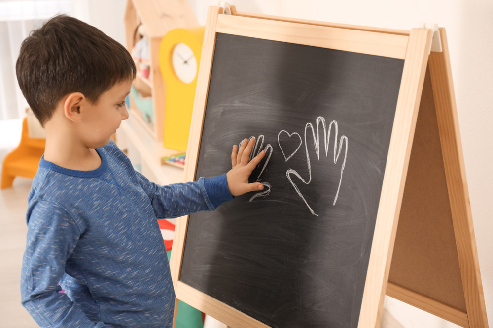 A child with his hand drawn round in chalk